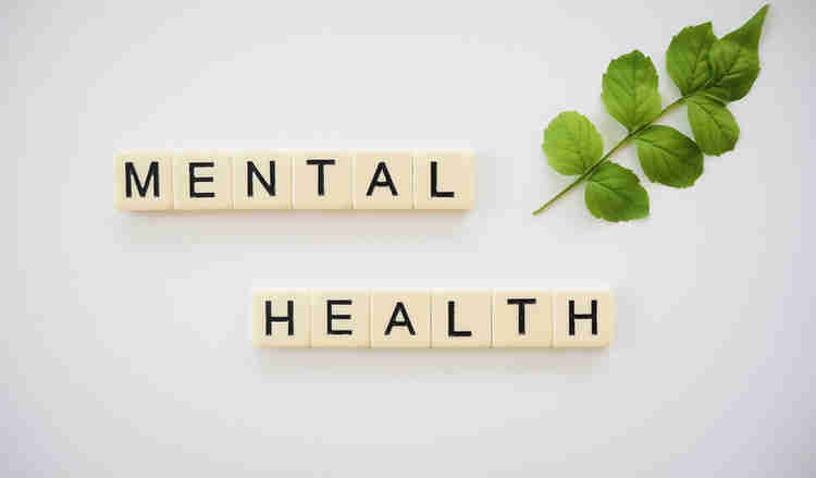 'Mental health' written with scrabble set with leaf